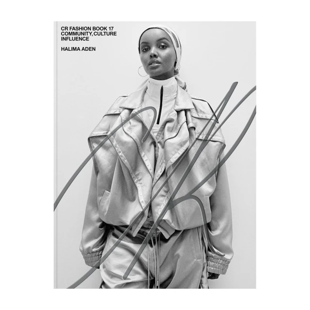 Black and white fashion shot of Halima Aden in an oversized jacket and head covering for CR Fashion Book. Studio setting, neutral backdrop.