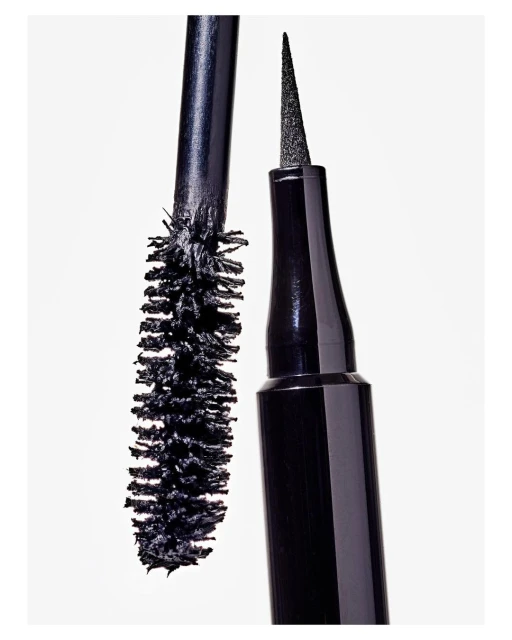 Close-up shot of black eyeliner and mascara wands with synthetic bristles against a bright white backdrop, beauty product display.
