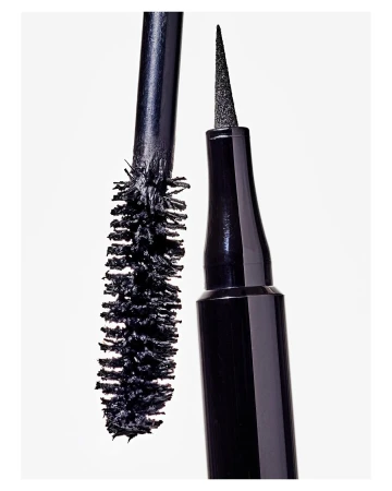 Close-up shot of black eyeliner and mascara wands with synthetic bristles against a bright white backdrop, beauty product display.