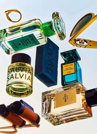Still life featuring perfume bottles from Tom Ford, Celine, and other luxury brands, along with sunglasses, soap, a ring, and binoculars.