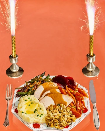 Celebratory Thanksgiving dinner on a white plate with sides of potatoes, stuffing, green beans, carrots, and cranberry sauce, sparkler candles.