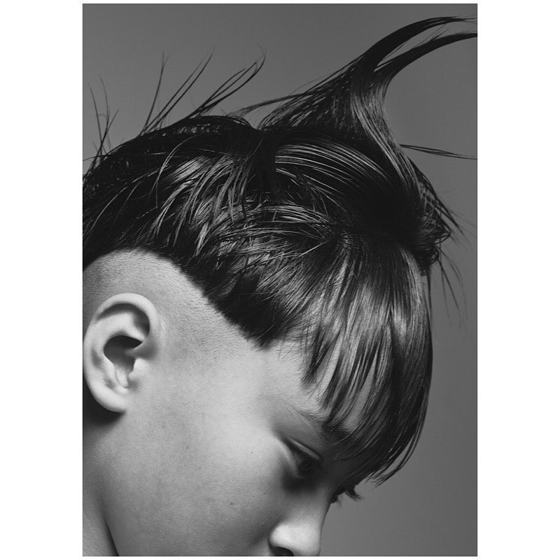 Striking black and white portrait of a person with an edgy undercut hairstyle, showcasing bold fashion and beauty aesthetics.
