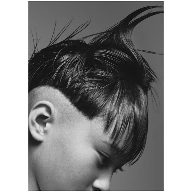 Striking black and white portrait of a person with an edgy undercut hairstyle, showcasing bold fashion and beauty aesthetics.