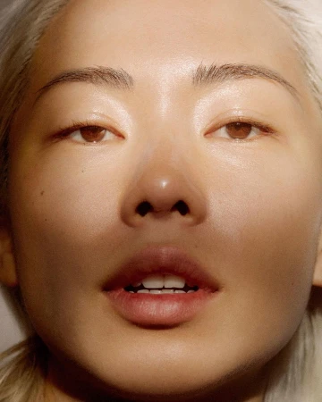 Extreme close-up beauty portrait of a woman with glowing skin and light blonde hair by Johanna Nyholm
