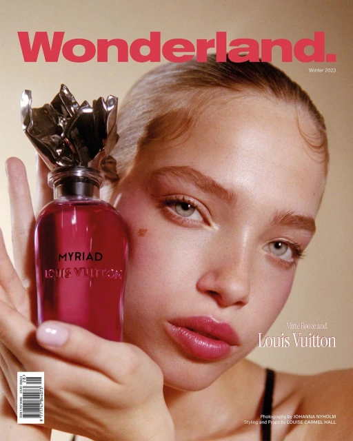Wonderland magazine cover featuring a model holding a Louis Vuitton perfume bottle with a silver topper and pink liquid.
