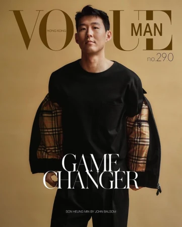 Portrait of Son Heung-min wearing a black t-shirt and jacket against a plain tan background for a magazine cover.