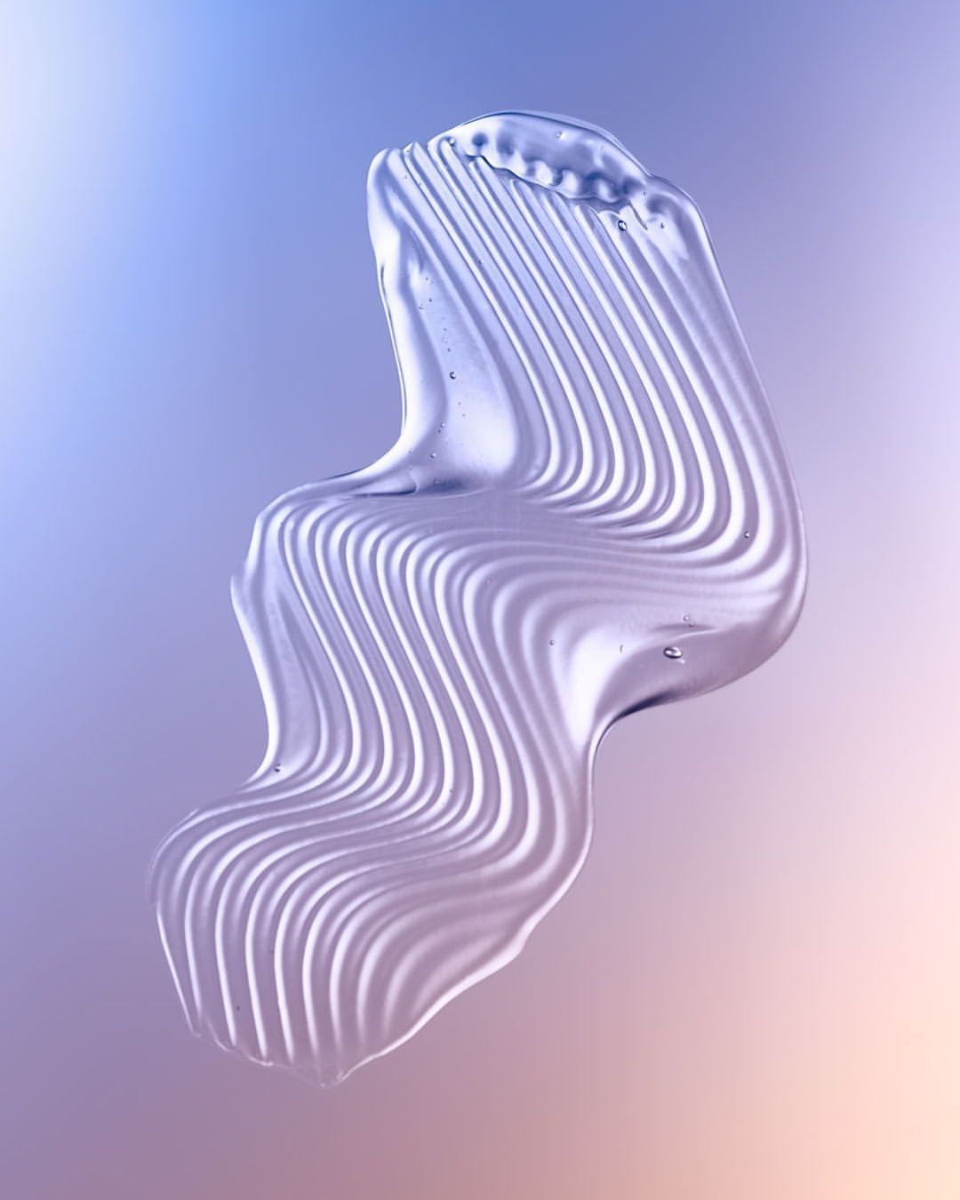 Abstract close-up of clear gel-like material with smooth, wavy lines against a gradient background in shades of purple and beige.