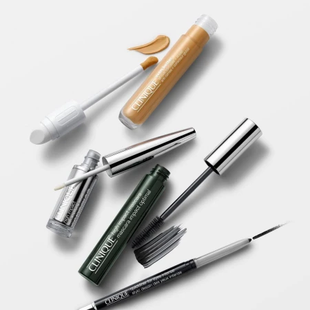 Clinique makeup set against white background with mascara, eyeliner, and concealer; a focus on product presentation and beauty.