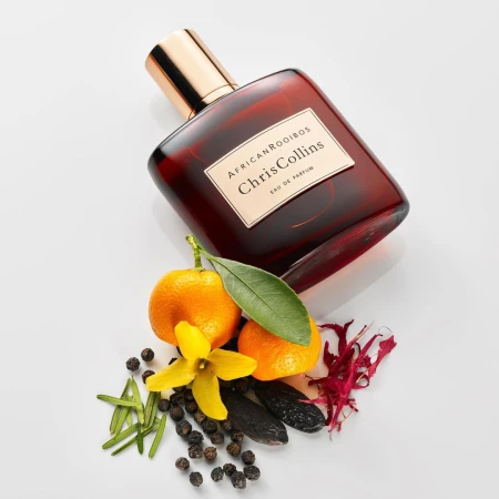 Chris Collins African Rooibos perfume bottle with mandarin, spices, and leaves against white seamless