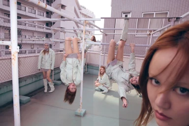 Multiple models in light green jackets posing on a rooftop, with a close-up portrait of a woman in the foreground.