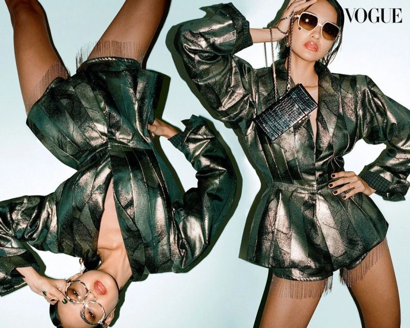 Fashion editorial featuring two young adult women wearing matching shiny striped jackets, skirts, and sunglasses in a studio setting.
