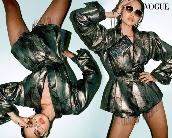 Fashion editorial featuring two young adult women wearing matching shiny striped jackets, skirts, and sunglasses in a studio setting.