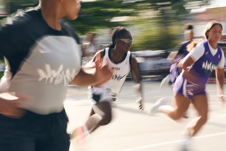 Three young athletes in sportswear run a race outdoors with motion blur. Track and field competition with athletic girls.