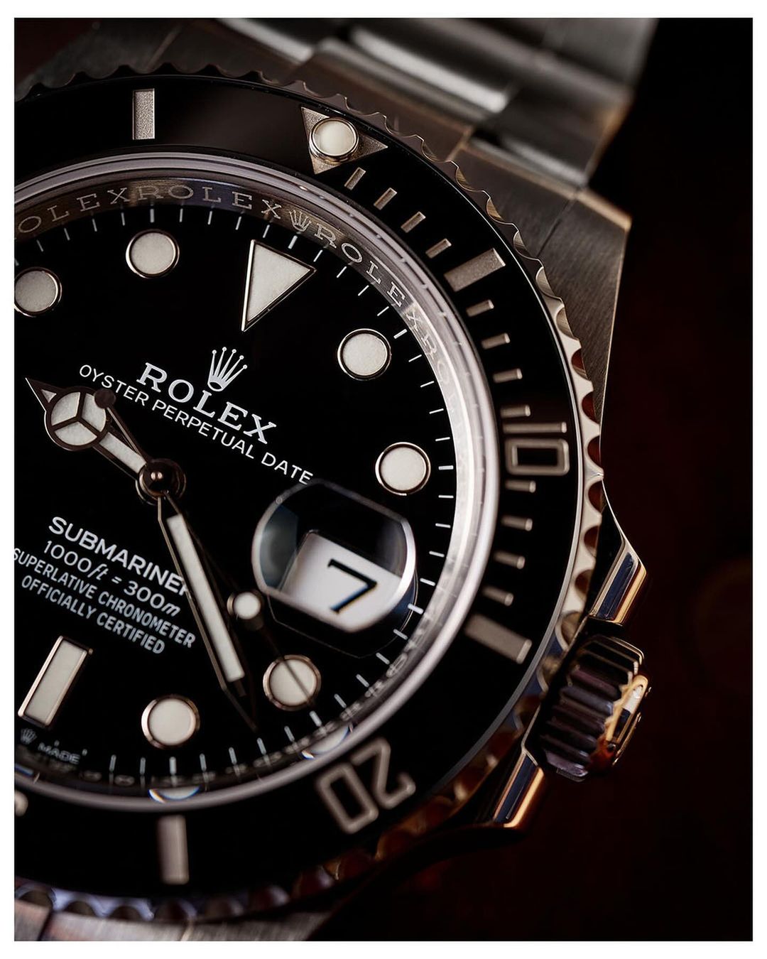 Close-up of a Rolex Submariner watch featuring a black dial, silver band, and prominent date window at the three o'clock position.
