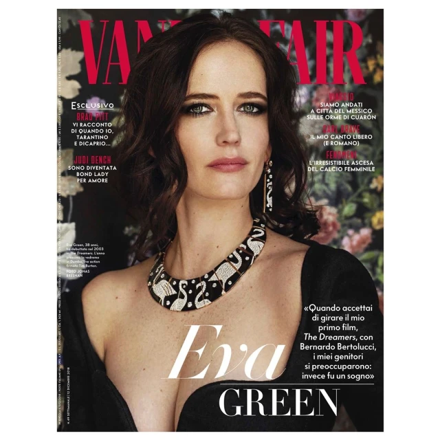 Magazine cover portrait of Eva Green wearing a black dress and statement flamingo necklace against a floral background