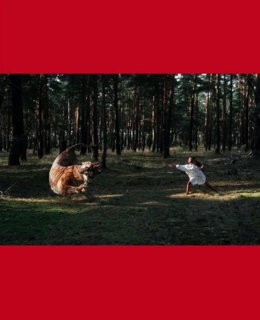 Woman in white confronts tiger in a dense forest, dramatic lighting, showcasing nature and wildlife interaction.