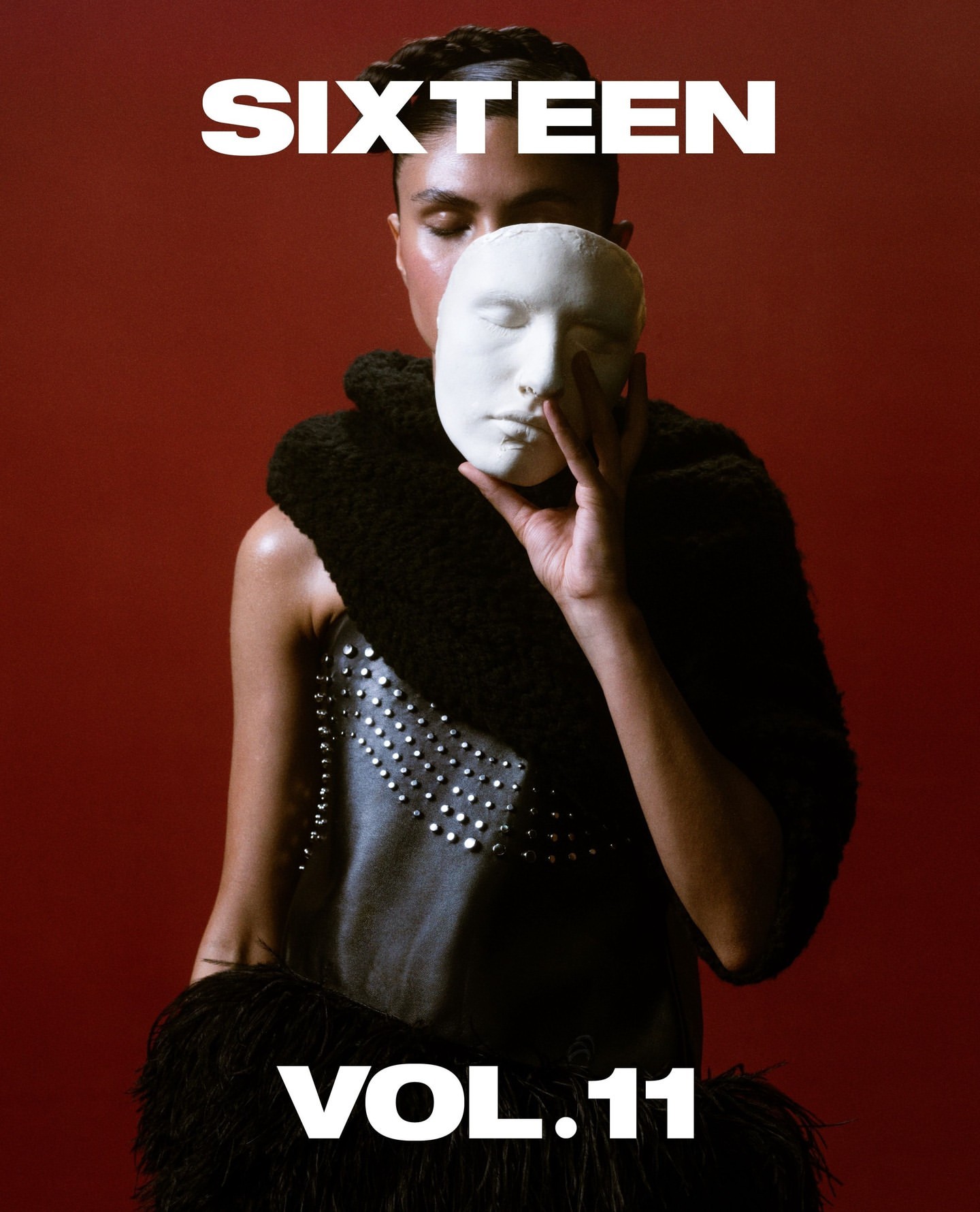 A person holds a white mask against a red background, wearing a studded top and black fuzzy boa with 'SIXTEEN VOL.11' text overlay.