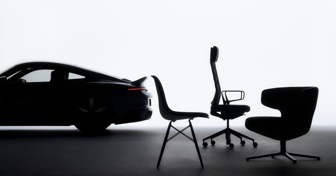 Silhouette of a modern black Porsche car positioned alongside three contemporary black office chairs against a bright, minimalist backdrop.