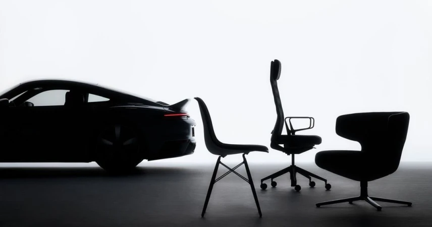 Silhouette of a modern black Porsche car positioned alongside three contemporary black office chairs against a bright, minimalist backdrop.