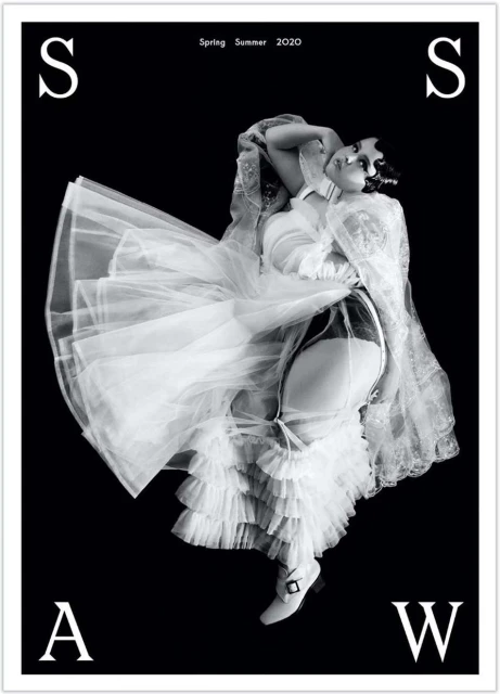 Black and white fashion shot featuring a woman in lingerie and a long, ruffled dress, with an 'S' and 'A' visible on the black background.