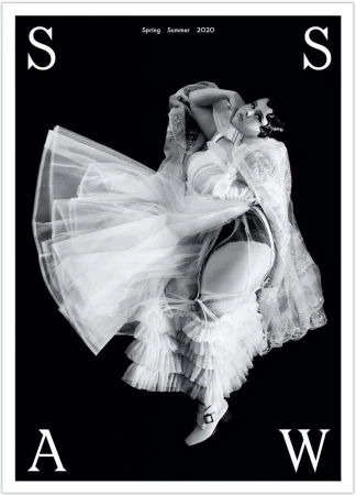 Black and white fashion shot featuring a woman in lingerie and a long, ruffled dress, with an 'S' and 'A' visible on the black background.