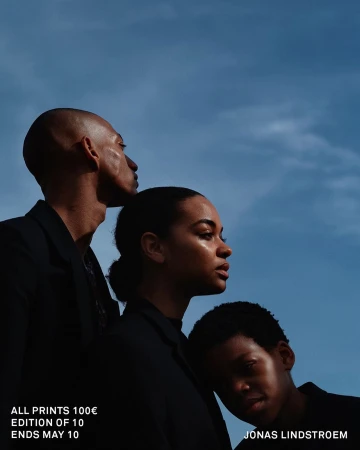Low angle shot of three people in black jackets against a clear blue sky by Jonas Lindstroem