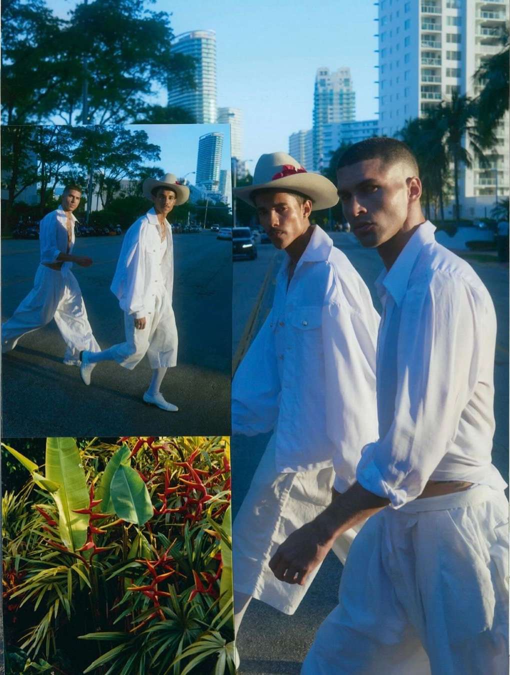 Two adult males in white shirts and hats walk on a city street with palm trees, buildings, and tropical foliage in bright daylight.