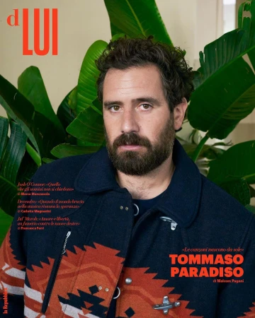 Magazine cover portrait of Tommaso Paradiso, Italian musician, wearing patterned jacket, with plant and magazine text in background.