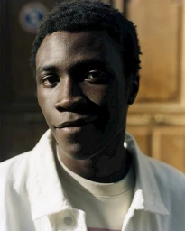 Portrait of a Black man in a white jacket outdoors in Paris photographed by Jonas Unger