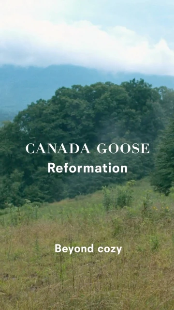 Scenic view of lush green hills and mountain range with Canada Goose and Reformation text overlay; clear sky and natural light.