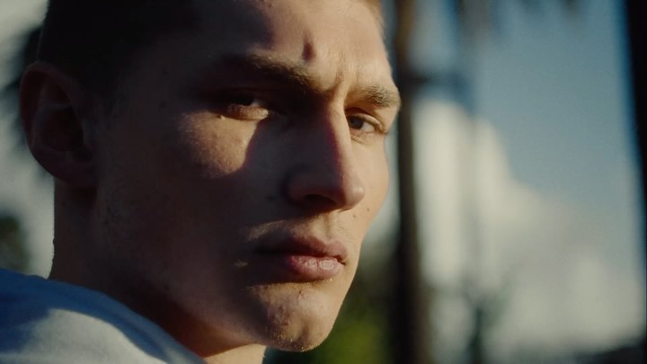Close-up portrait of a young man with a serious expression in warm natural sunlight by Jonathan Heller