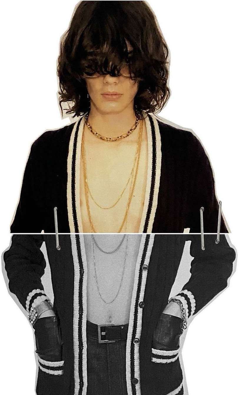 A person with dark hair and gold necklaces wears a cardigan in a studio shot against a white background. Half of the person is in grayscale.