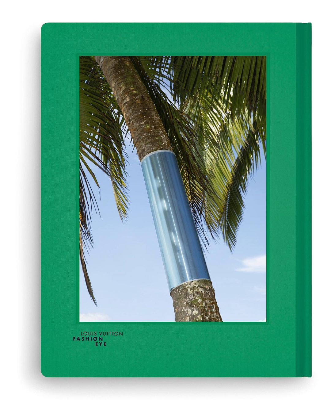 The cover of Louis Vuitton's 'Fashion Eye' book features a palm tree with a blue reflective accent against a light blue sky.