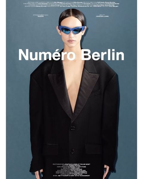 Editorial shot of a woman in a black suit and blue sunglasses in front of a teal background with the text 'Numéro Berlin' visible.
