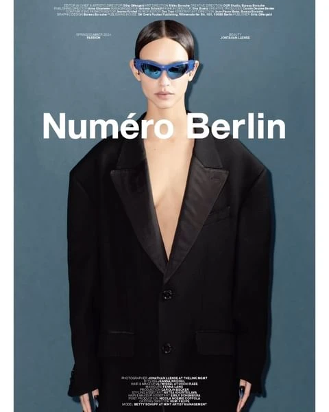 Editorial shot of a woman in a black suit and blue sunglasses in front of a teal background with the text 'Numéro Berlin' visible.