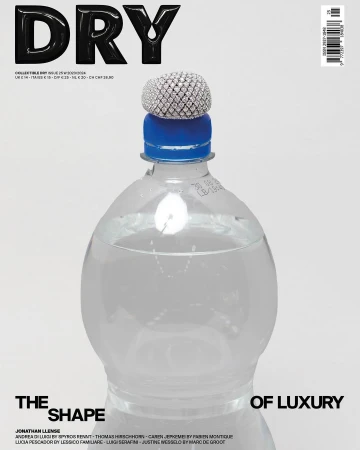 Plastic water bottle with a blue cap topped by a pavé diamond ring against a white backdrop for a magazine cover.