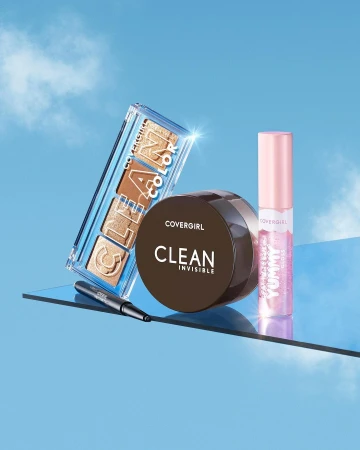 Still life shot of COVERGIRL makeup: an eye palette, a jar of foundation, an eyeliner, and a lip gloss against a blue sky.