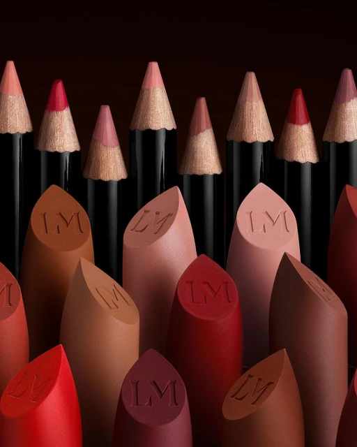 Close-up studio shot of a set of lipsticks and lip pencils in various colors, arranged in a visually appealing composition.