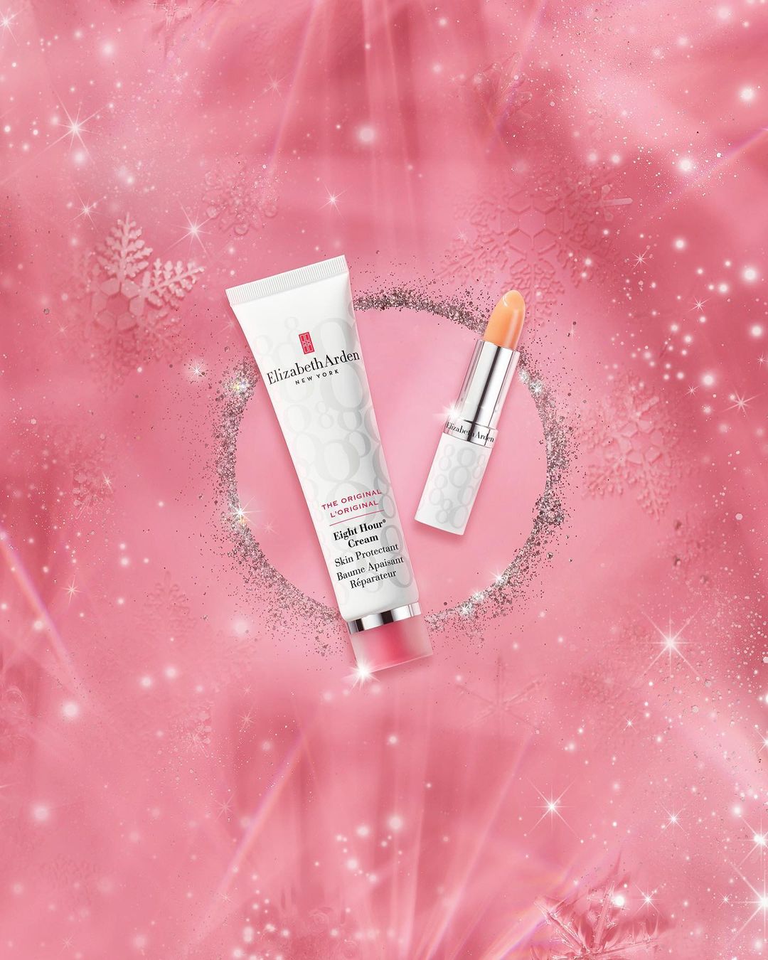 Elizabeth Arden skincare and lipstick products displayed on a pink background with bokeh lights and sparkles for a beauty product shot.