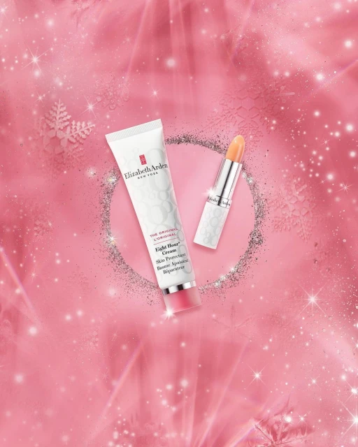 Elizabeth Arden skincare and lipstick products displayed on a pink background with bokeh lights and sparkles for a beauty product shot.