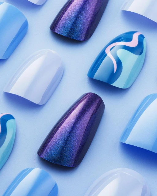Close-up of an array of artificial nails featuring varying shades of blue, purple, and white on a light-blue background. Beauty product shot.