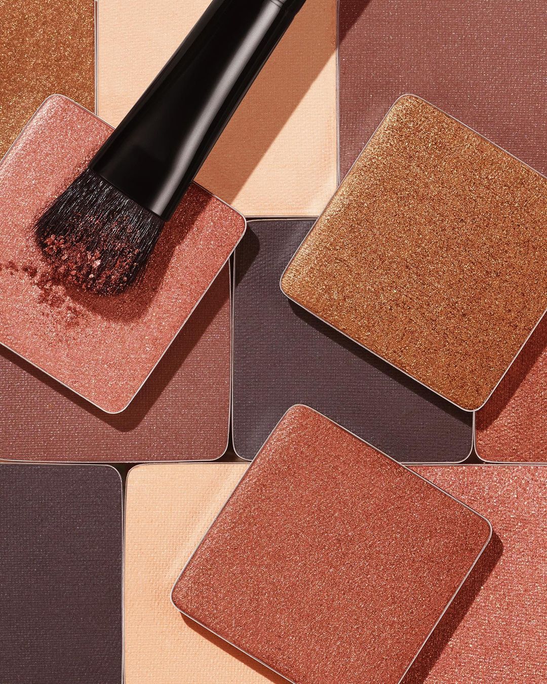 Square eye shadow palette with makeup brush applicator, close-up still life, beauty shot for cosmetic advertising and product display.