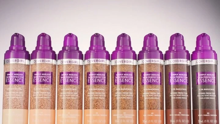Multiple shades of CoverGirl Simply Ageless Skin Perfector Essence foundation bottles arranged against a light backdrop.