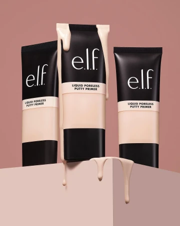Three black tubes of e.l.f. Liquid Poreless Putty Primer are staged on a geometric stand against a light brown background, product spilling.