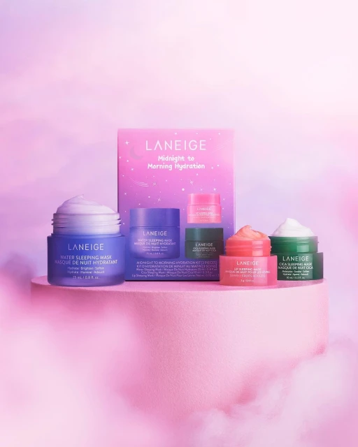 Laneige skincare product line featuring water sleeping masks and lip sleeping masks in variety of colors, displayed on pink platform.