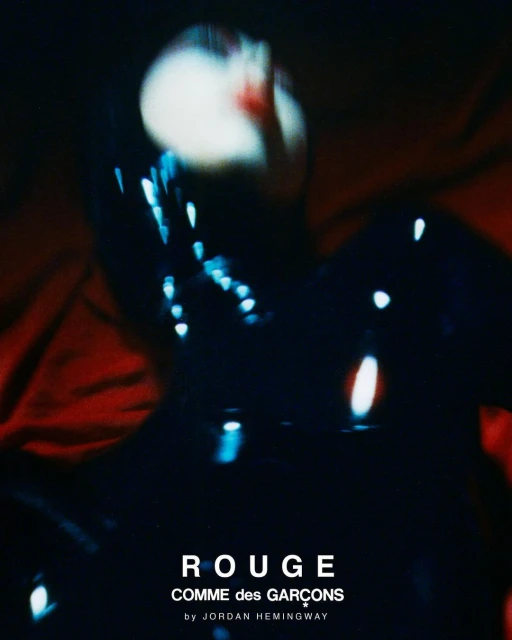Fashion editorial featuring a blurry figure in a black garment on a red background with text overlay: ROUGE COMME des GARCONS.