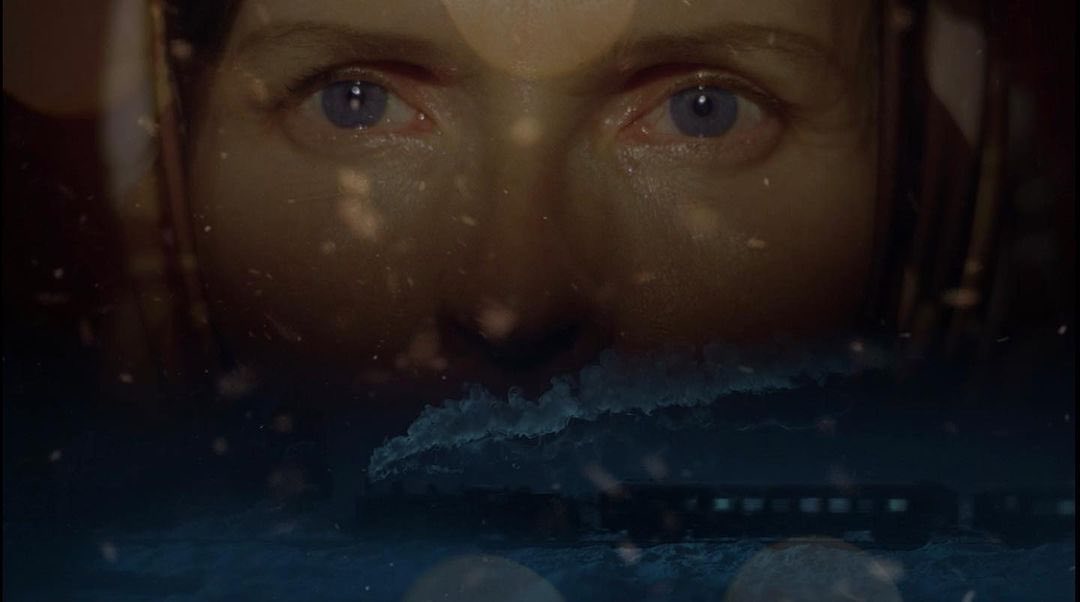 Dramatic close-up of adult female eyes with a train running in the lower section of the image; moody and mysterious.