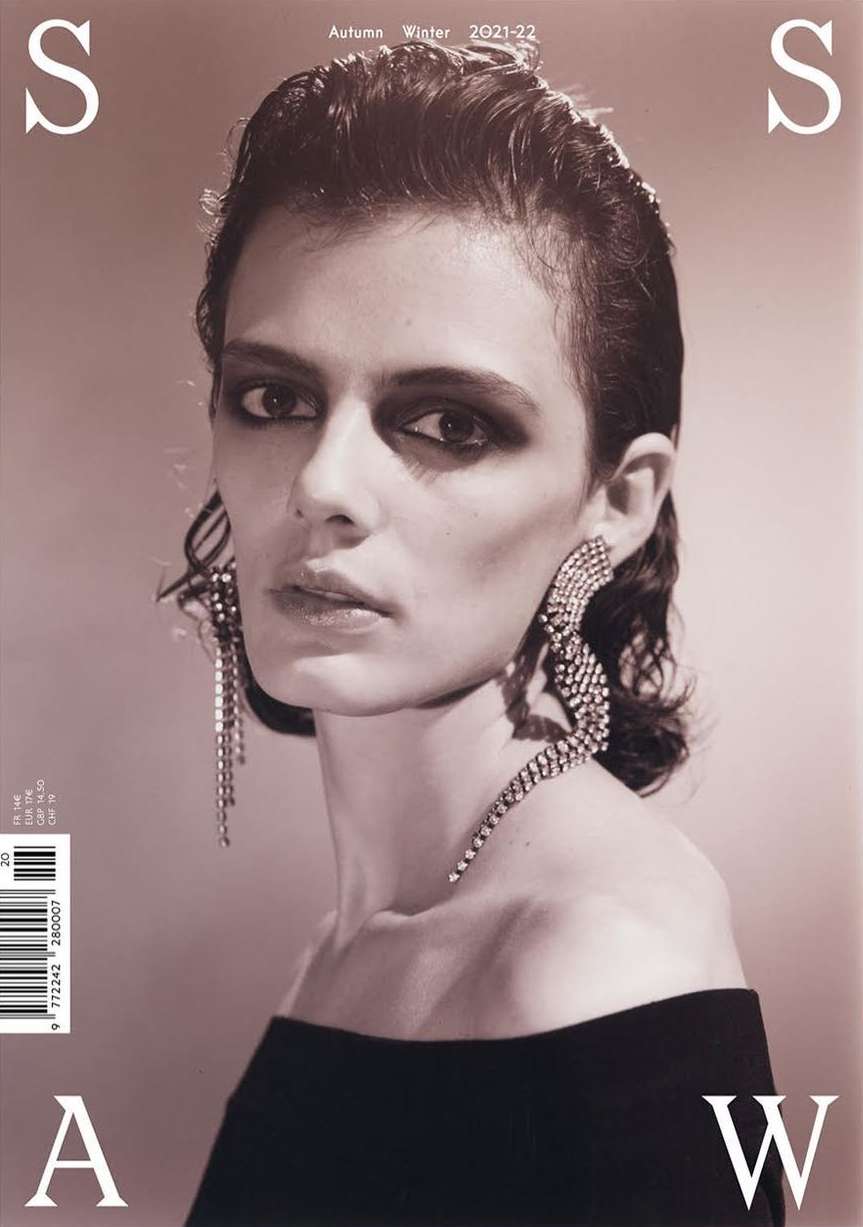 Fashion magazine cover featuring a model with bold eyeshadow and statement earrings, showcasing autumn-winter 2021-22 collection.