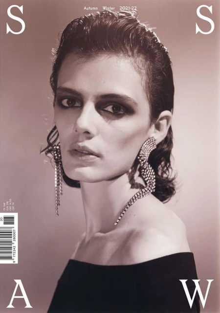 Fashion magazine cover featuring a model with bold eyeshadow and statement earrings, showcasing autumn-winter 2021-22 collection.