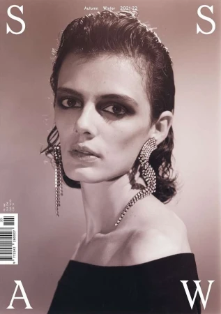 Fashion magazine cover featuring a model with bold eyeshadow and statement earrings, showcasing autumn-winter 2021-22 collection.